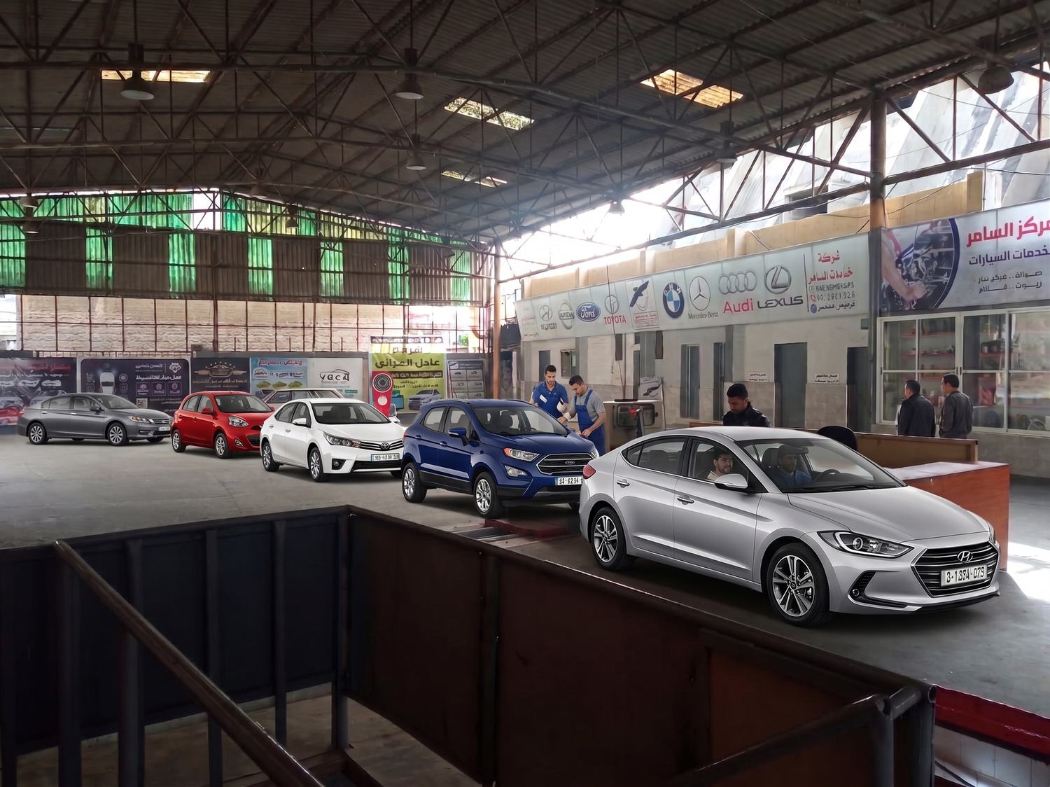 Inside the Saamir workshop on Omar Al Mukhtar Street — vehicles on the inspection lane and staff at work, beneath the manufacturer marques the business has served.